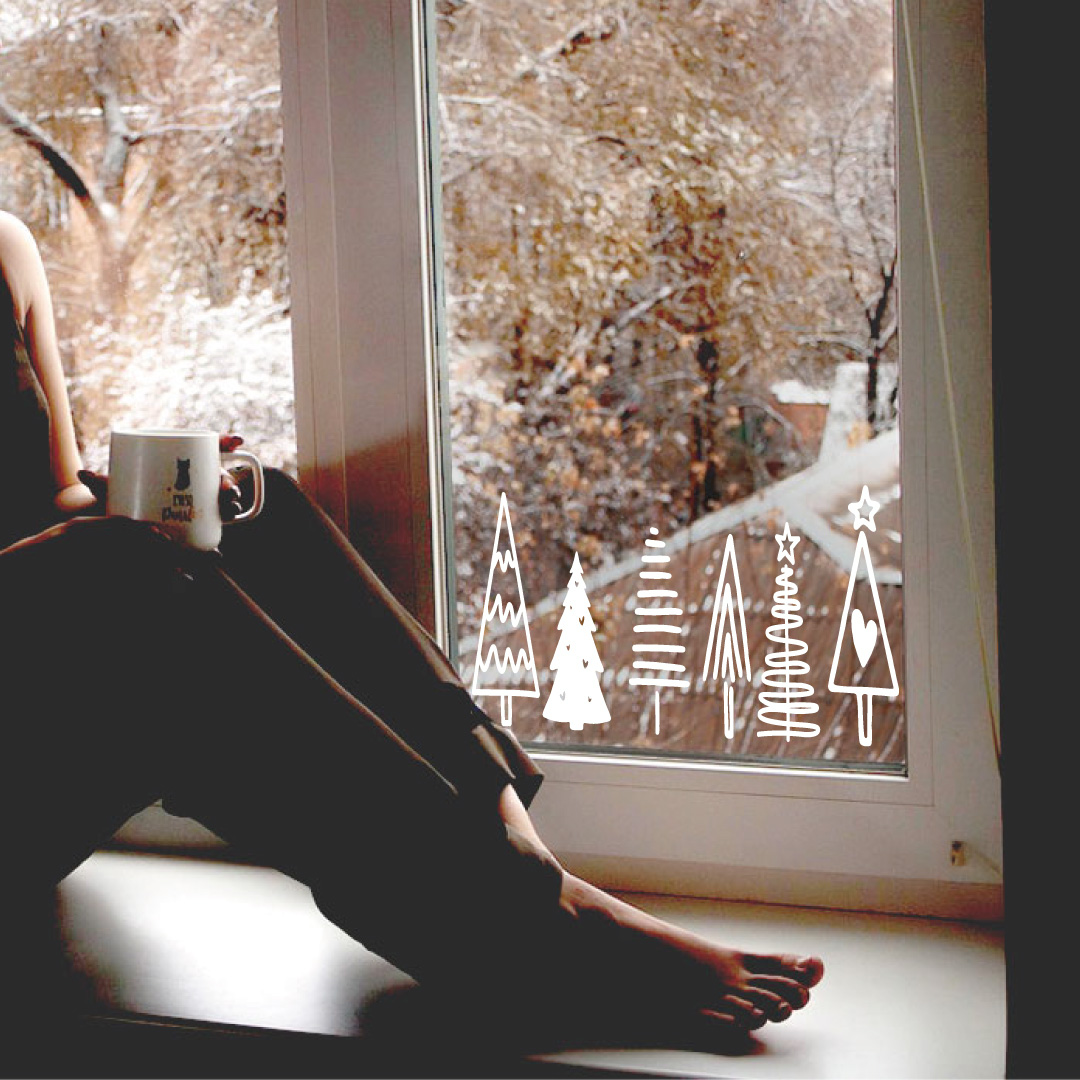 Weiße Weihnachtsbäume als Folienbeschriftung auf Fenster.